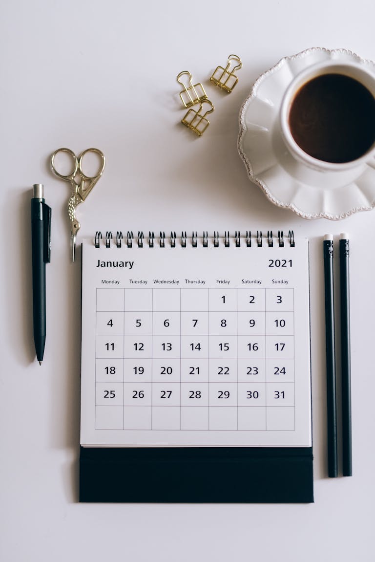 A calendar or planner with written goals and a coffee cup nearby.