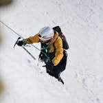 A person climbing a mountain or navigating through a storm with determination.