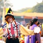 A confident person holding up a calm hand, with a blurred crowd in the background.