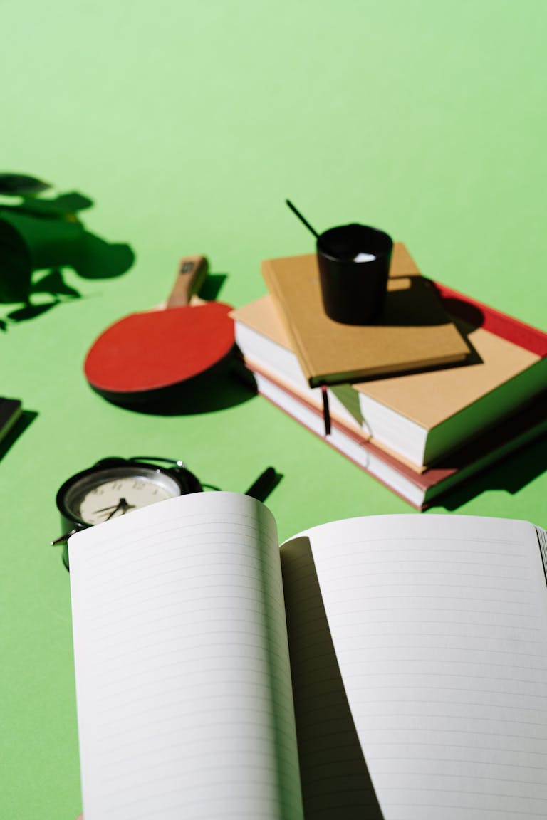A desk overflowing with papers, a clock in the background, and a checklist highlighting one item in green.
