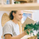 A person reading a book with a clock behind them showing 1 hour blocks