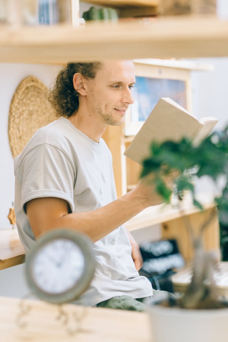 A person reading a book with a clock behind them showing 1 hour blocks