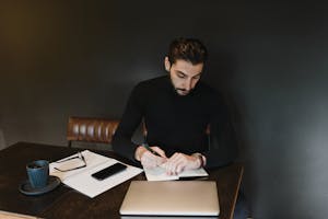 A person organizing their workspace, with a to-do list, a cup of coffee, and a calendar, symbolizing productive habits.