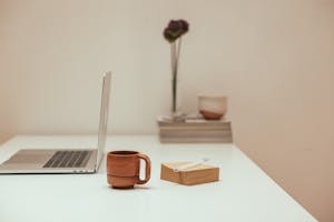 A calm workspace with just a laptop, coffee, and a notepad—symbolizing focus and simplicity.