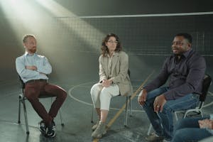 A group of people having a conversation, with one person actively listening and engaged.