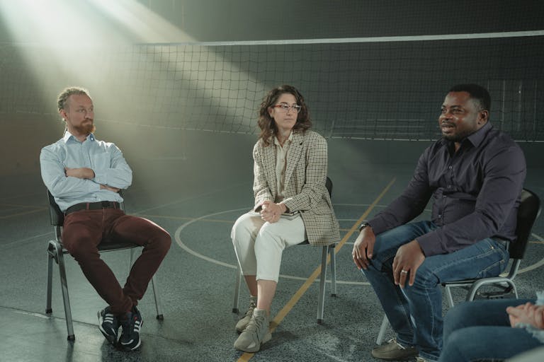 A group of people having a conversation, with one person actively listening and engaged.