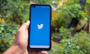 A person closing social media apps on a phone or setting a timer while working