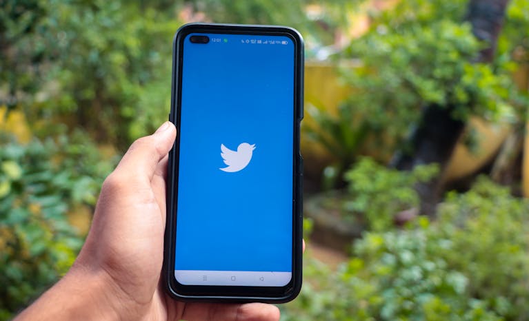 A person closing social media apps on a phone or setting a timer while working