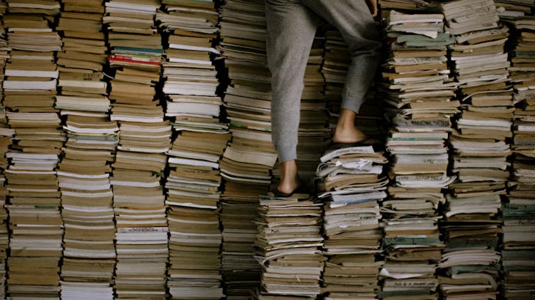 A person climbing a staircase made of books with arrows pointing upward.