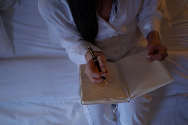 A calm, cozy nighttime setting with a person journaling or preparing for bed with soft lighting.