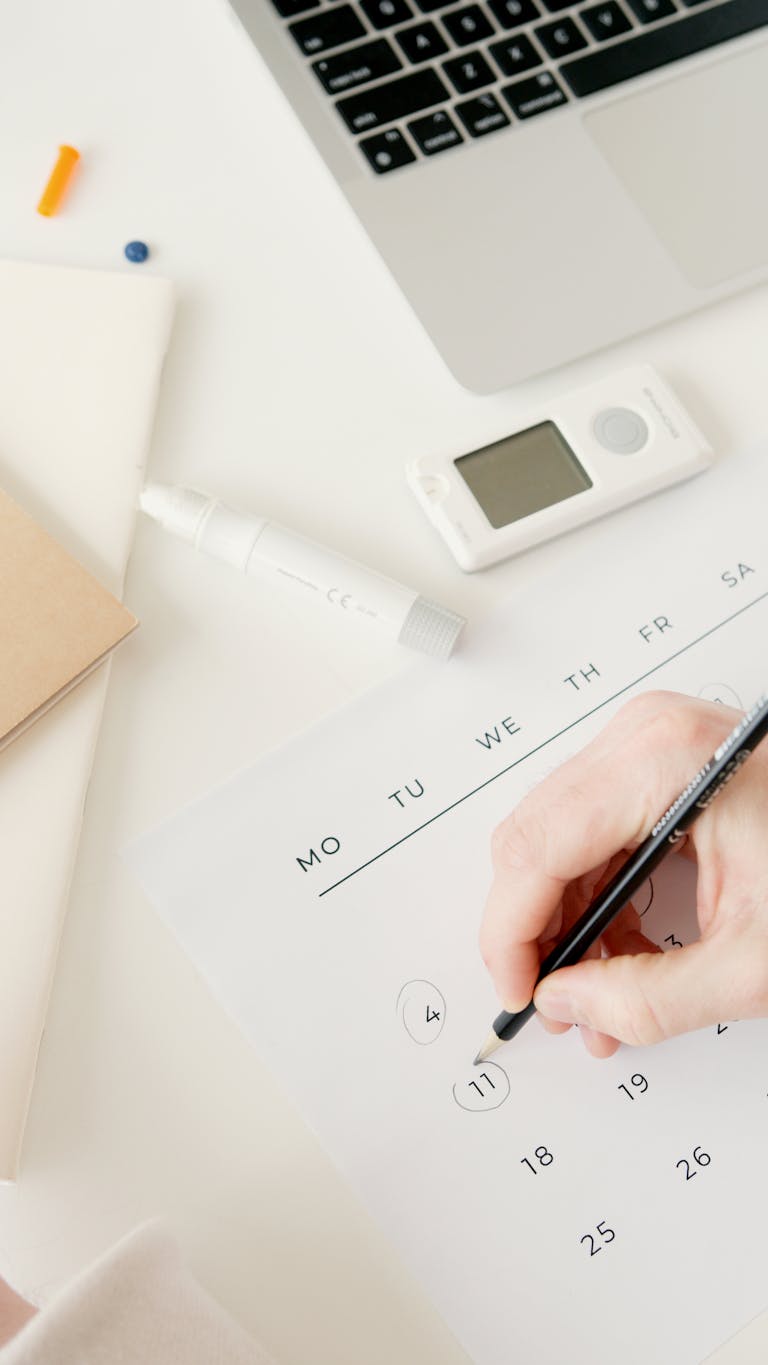 A person using a planner or digital calendar with a clock in the background