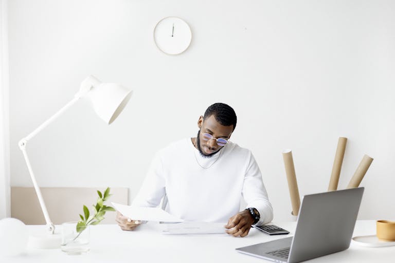 A person working at a clean desk while ignoring smartphone notifications in the background.
