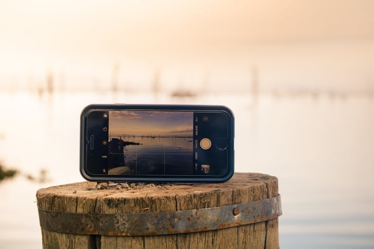 A serene nature path with a smartphone left behind on a bench, symbolizing digital disconnection.