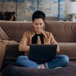 A person working from home with a clear boundary between work and personal life, possibly using a laptop, with a balanced workspace featuring elements of relaxation and productivity.