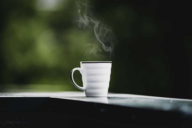 A peaceful morning scene with a cup of coffee, a journal, and a rising sun in the background