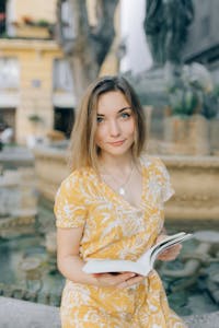 A person relaxing in nature, holding a book, with no electronic devices in sight