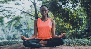 A person meditating in nature with their phone turned off