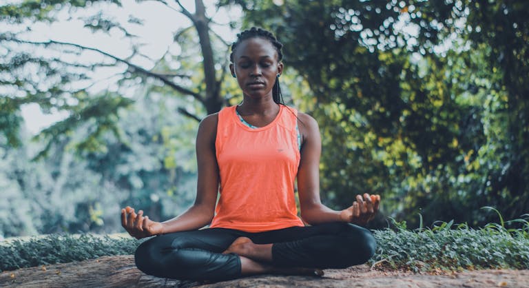 A person meditating in nature with their phone turned off