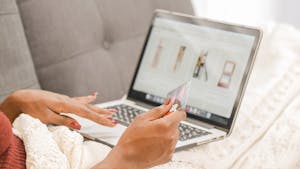 A person overwhelmed by digital content, sitting with multiple screens and shopping apps open