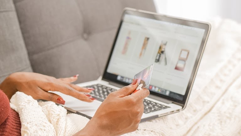 A person overwhelmed by digital content, sitting with multiple screens and shopping apps open