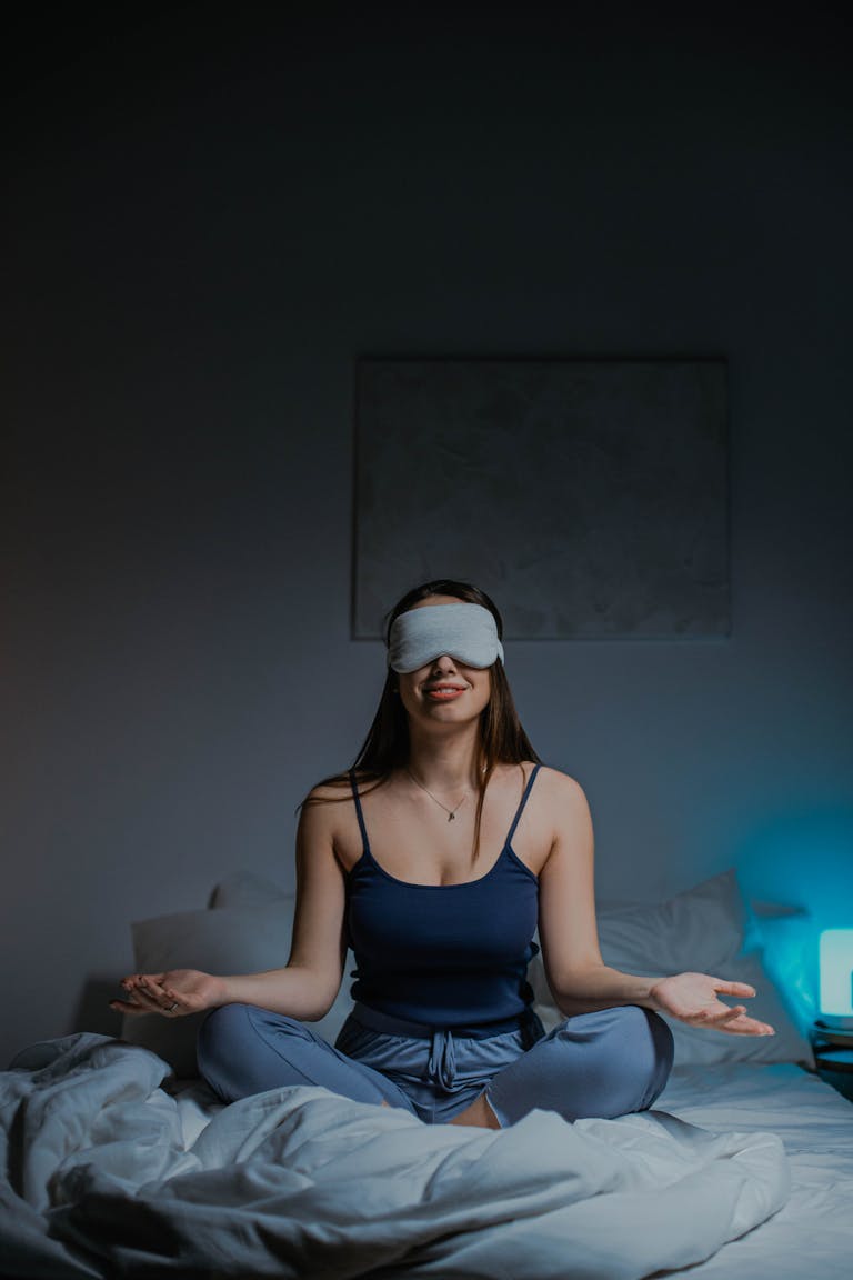 A person practicing yoga or meditating in a calm environment with soft lighting.