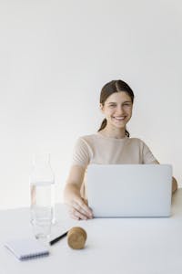 A person working at a bright desk with a timer and a water bottle, looking energized