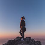 A person climbing a steep trail at sunrise with determination.