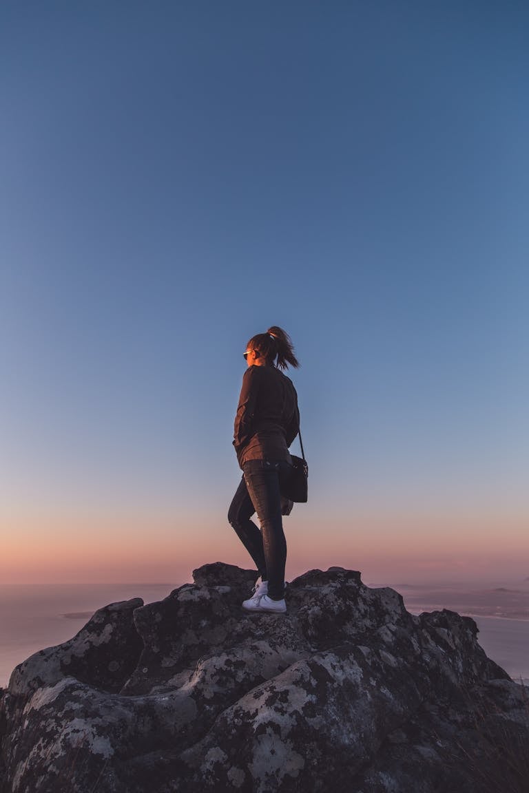 A person climbing a steep trail at sunrise with determination.