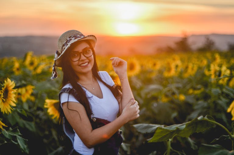 A person smiling while looking at a sunrise or a happy person engaging in an uplifting activity