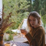 A person relaxing outdoors while their phone is placed facedown on a table.