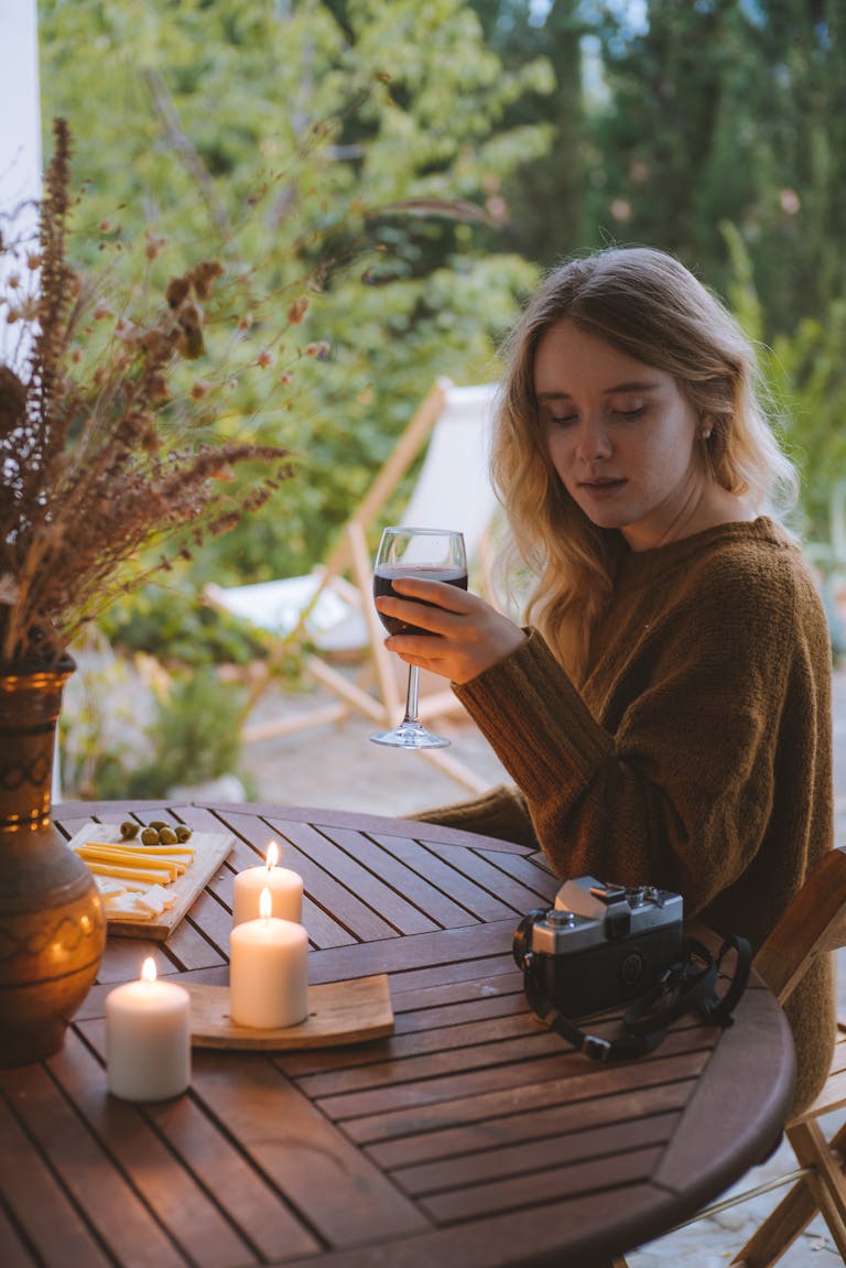 A person relaxing outdoors while their phone is placed facedown on a table.