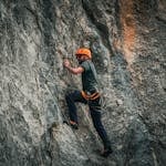 A determined person climbing a steep hill with a focused look