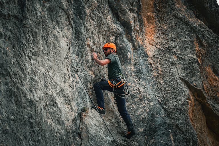 A determined person climbing a steep hill with a focused look