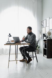 A person working at a minimalist desk with no phone or distractions, focused on a laptop