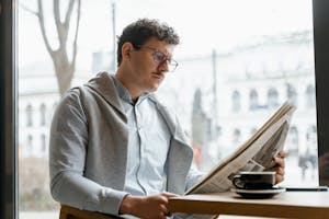 A person stretching by a window with morning sunlight pouring in, a journal and coffee nearby.