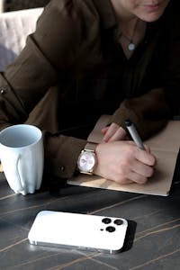 A serene workspace showing a smartphone turned face down next to a notebook