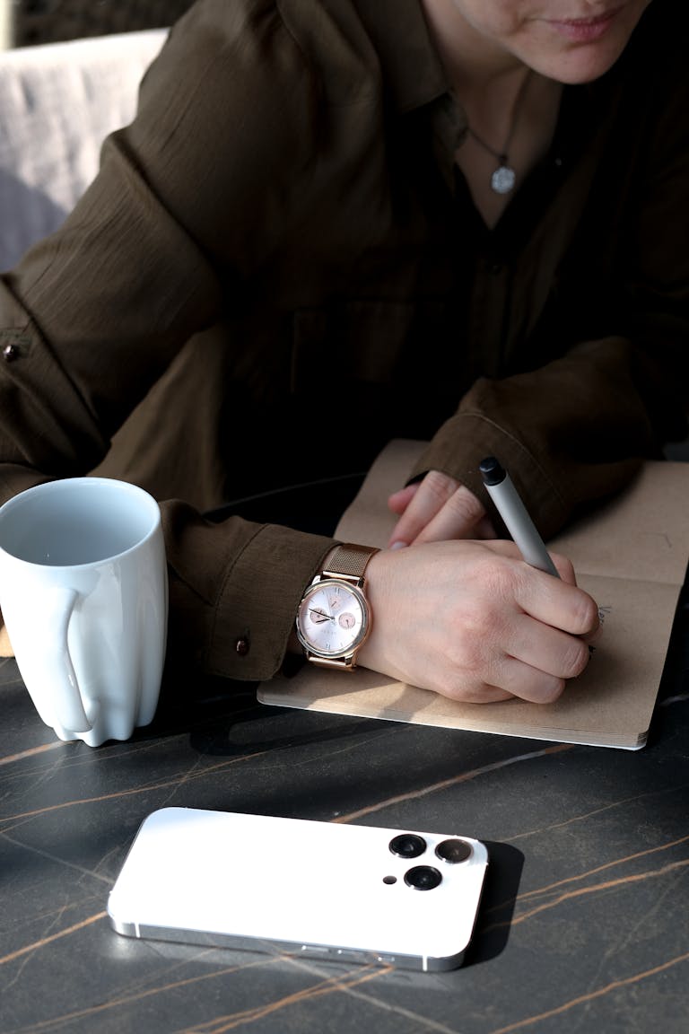 A serene workspace showing a smartphone turned face down next to a notebook