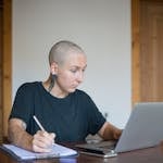 A person meditating or working at a desk with a clean, organized workspace, looking focused.
