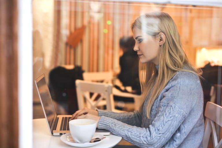 A person balancing work and relaxation activities, such as a laptop and a cup of tea.