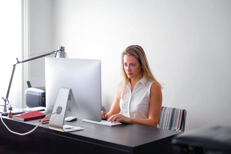 A focused person working at a minimalist desk while phones and notifications are silenced.