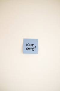 A ticking clock next to a small sticky note that says “Just Start”