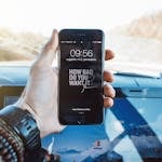 A smartphone with dozens of notifications blurred, while one calm alert stands out clearly in focus.