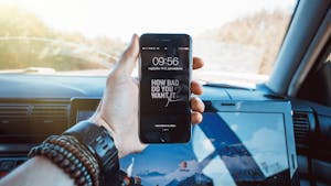 A smartphone with dozens of notifications blurred, while one calm alert stands out clearly in focus.