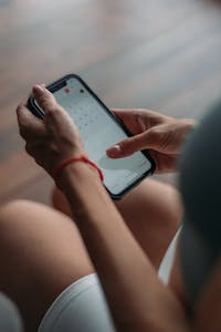 A person using a calendar app to create time blocks on their phone or laptop.