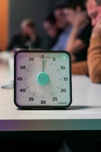 A person checking off a to-do list with a timer set to 15 minutes beside them