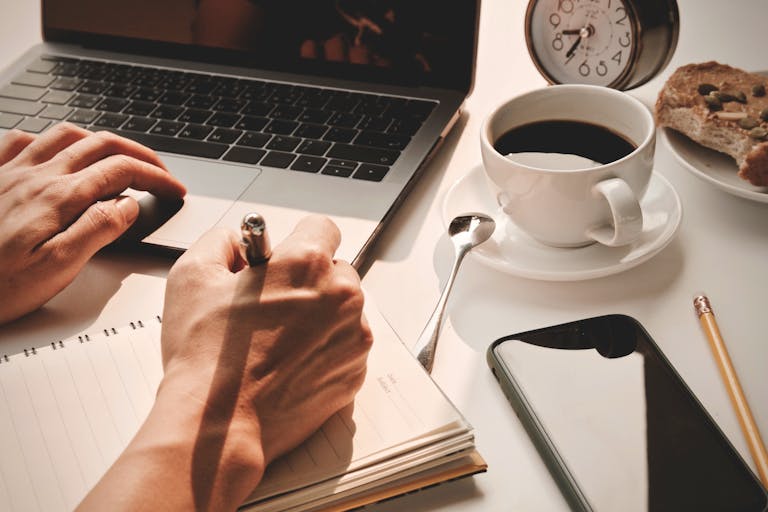 A calm workspace with a clock, notebook, and coffee—symbolizing peace and control over time.