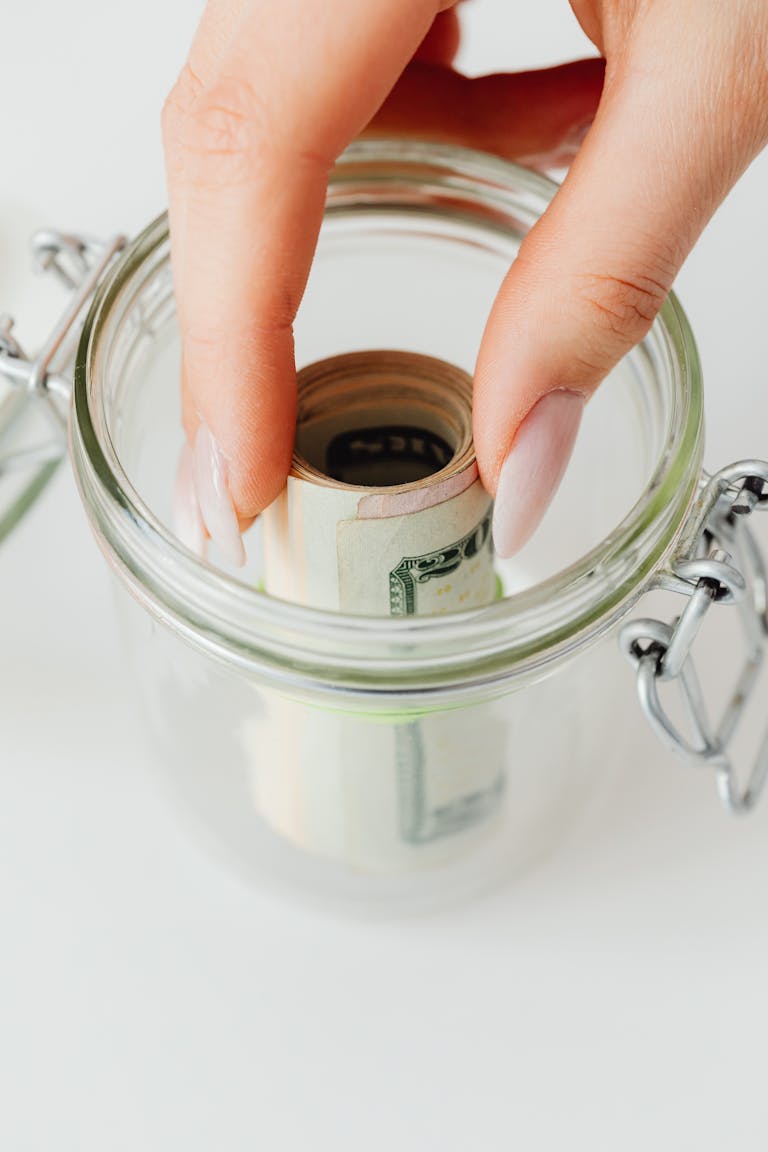A jar labeled "Emergency Fund" filling up with coins and bills