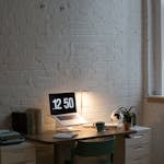 A well-organized desk with a planner, clock, and coffee cup, symbolizing efficient time management.