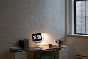 A well-organized desk with a planner, clock, and coffee cup, symbolizing efficient time management.