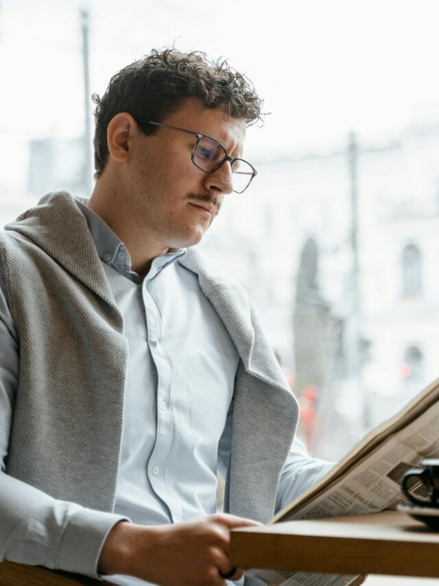 A person stretching by a window with morning sunlight pouring in, a journal and coffee nearby.